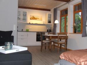 a living room and kitchen with a table and chairs at Hof Sturenberg in Quarnbek