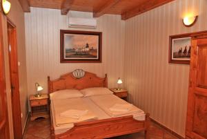 a bedroom with a bed and two night stands with lamps at Berényi Fogadó in Nagykanizsa