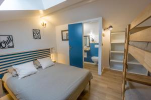 a bedroom with a bed and a bunk bed at Wood'n Sea Surf Lodge - Auberge De Jeunesse in Capbreton
