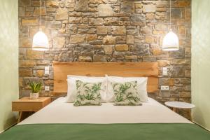 um quarto com uma cama grande e uma parede de pedra em Αngelikon Luxurious Apartments em Agios Ioannis Kaspaka