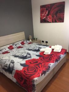 a bedroom with a bed with red roses on it at Da Lenny: a due passi dal centro storico in Treviso