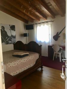 1 dormitorio con 1 cama, 1 silla y 1 ventana en B&B CASA mia - camere in appartamento privato -, en Sossano