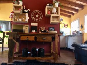a living room with a table and a clock on a wall at B&B CASA mia - camere in appartamento privato - in Sossano
