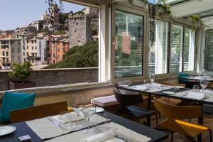 a restaurant with tables and chairs and a view of the city at Grand Hotel Portovenere in Portovenere