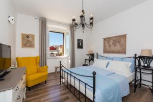 a bedroom with a bed and a yellow chair at Skipper Suites in Novigrad Istria