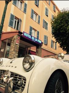a white car parked in front of a building at Hotel de La Paix in Corte