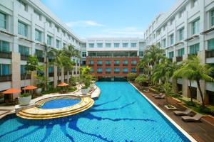 雅加达Ibis Styles Jakarta Mangga Dua Square的建筑物中间的一个大型游泳池