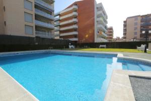 a large blue swimming pool in front of some buildings at Roura Planet Costa Dorada in La Pineda