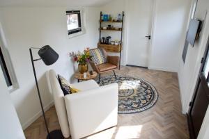 a living room with a couch and a chair at Het Torentje aan de IJssel in Montfoort