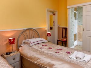 a bedroom with a bed with flowers on it at The Warren Guest House in Carlisle