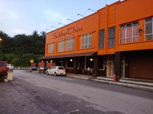 un bâtiment orange sur le côté d'une rue dans l'établissement Hotel 77 Rawang, à Rawang