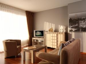 a living room with a couch and a television at Apartamenty Złota Nić in Opole