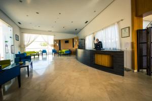 a lobby with a person sitting on a laptop at Suites Hotel Mohammed V by Accor in Al Hoceïma