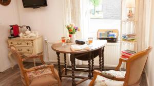 een kamer met een tafel, 2 stoelen en een raam bij Casa Mia Sittard in Sittard