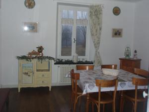 uma sala de jantar com uma mesa e cadeiras e uma janela em Ferme du Haut Barba em Liézey