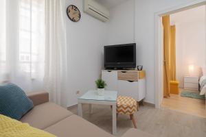 a living room with a couch and a tv and a table at Apartments CenterLink in Split