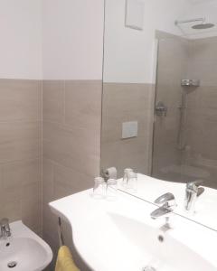 uma casa de banho com 2 lavatórios e um chuveiro em Hotel Pension Schweitzer em Silandro