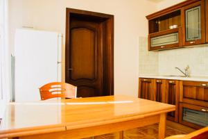 una cucina con tavolo in legno e frigorifero di Private house under the key Amra a Gagra