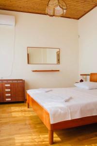1 dormitorio con cama y espejo en la pared en Private house under the key Amra, en Gagra