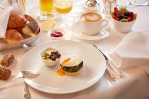 a table with a plate of breakfast foods and coffee at Hotel Schweizerhof Zürich in Zurich
