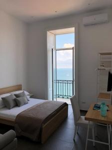 1 dormitorio con cama y vistas al océano en Lux, en Nápoles