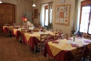 a room with tables and chairs with red and yellow table cloth at Albergo Diffuso Faller in Faller