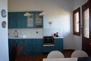 a kitchen with blue cabinets and white counter tops at Marvelous Sea View Eco Apt in Ammouliani