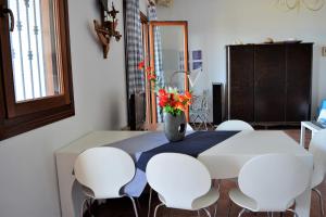 a dining room table with white chairs and a vase with flowers at Marvelous Sea View Eco Apt in Ammouliani