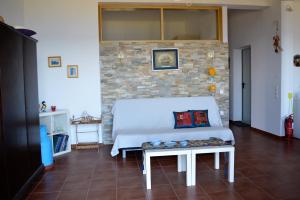 a bedroom with a white bed and a brick wall at Marvelous Sea View Eco Apt in Ammouliani