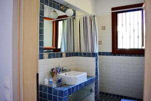 a blue tiled bathroom with a sink and a mirror at Marvelous Sea View Eco Apt in Ammouliani +37 photos