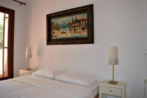 a bedroom with a bed with a picture on the wall at Marvelous Sea View Eco Apt in Ammouliani