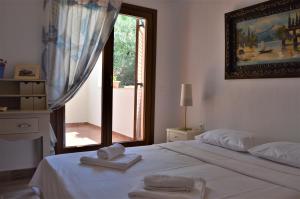 a bedroom with a white bed with two towels on it at Marvelous Sea View Eco Apt in Ammouliani