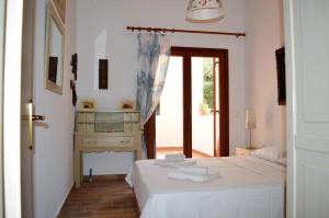 a bedroom with a bed and a table and a window at Marvelous Sea View Eco Apt in Ammouliani