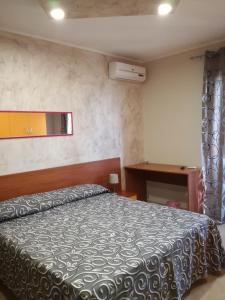 1 dormitorio con cama, ventana y escritorio en Anthea Dell' Etna, en Santa Venerina