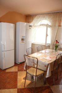 a kitchen with a table and a white refrigerator at Casa Monica in Baile Felix