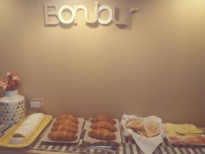 a table topped with different types of pastries and a sign at B&B Pane e Rose in San Miniato