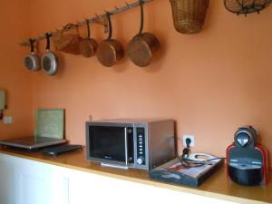um balcão de cozinha com micro-ondas, panelas e frigideiras em La Passagere em Hauterive