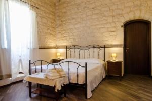 Un dormitorio con una cama y una mesa y una ventana. en Agriturismo Margione, en Módica