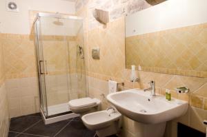 Un baño con lavabo, inodoro y ducha. en Agriturismo Margione, en Módica