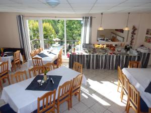 a restaurant with tables and chairs and a kitchen at Pensjonat Willa Edyta in Mrągowo