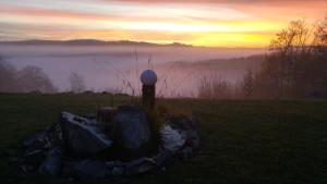a fire pit in a field with fog in the background at Berghaus Knopfmacher in Fridingen an der Donau