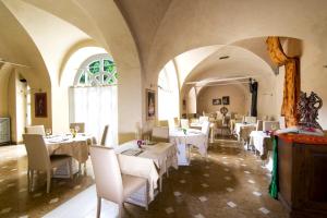 une salle à manger avec des tables et des chaises blanches dans l'établissement B&B Casa dei Poeti, à Mantoue