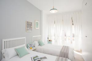 バレンシアにあるSingularStays Santa Claraの白いベッドルーム(ベッド2台、窓付)