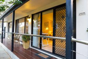 a balcony of a house with glass doors at Courtsidecottage Bed and Breakfast in Euroa