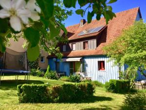 ein blaues Haus mit rotem Dach und einem Hof in der Unterkunft Haus Kunterbunt in Reichenberg