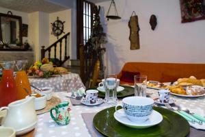 una mesa con platos de comida y tazas. en B&B La Gerbolina en San Giusto Canavese