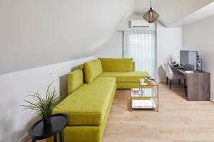 sala de estar con sofá amarillo y escritorio en B&B Sasput en Hasselt