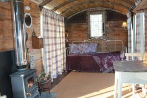 ein Schlafzimmer mit Bett und Holzofen in der Unterkunft Off the Rails in Oswestry + 12 Fotos