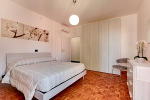 Schlafzimmer mit einem weißen Bett, einem Tisch und einem Schreibtisch in der Unterkunft Priuli Apartment in Venedig