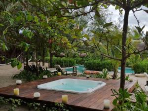 a hot tub sitting on a wooden table in a garden at The Beach Tulum Hotel in Tulum